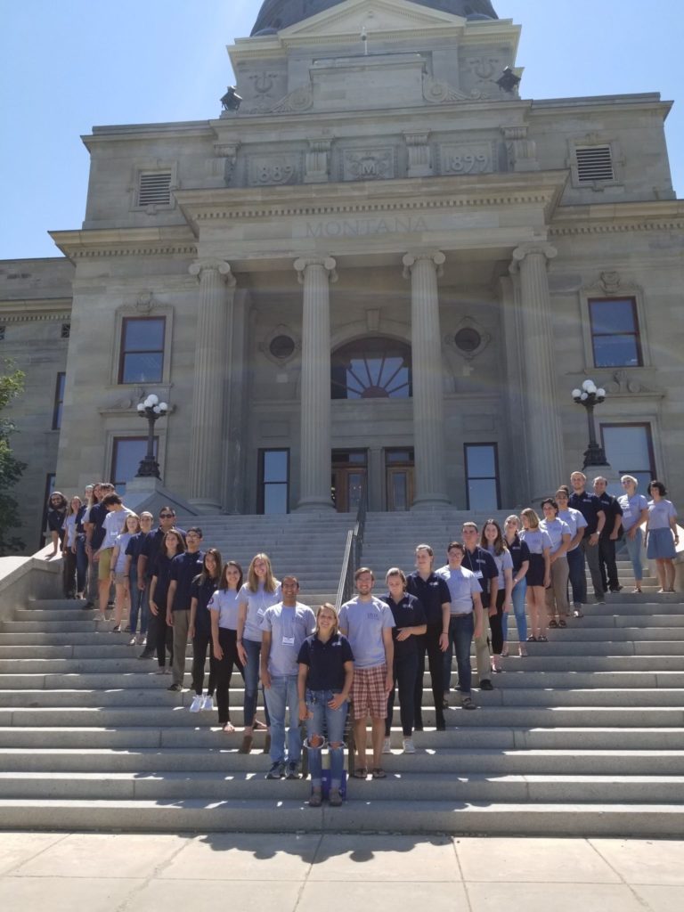 AmeriCorps members pose in V on steps of Montana state capitol